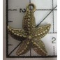 Decoración de metal dorada. Colgante estrella de mar. 2 x 2 cm. Fabscraps