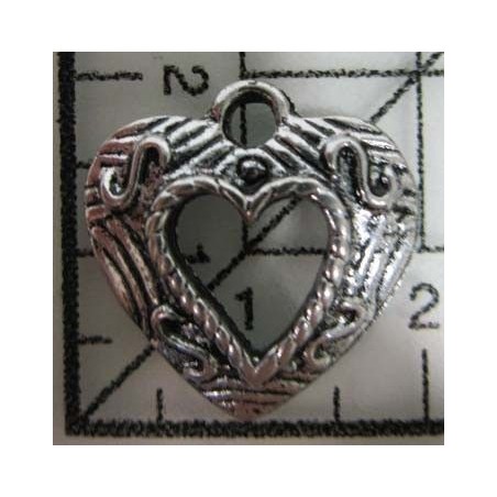 Decoración de metal plateada. Colgante corazón tallado, con centro vacio. 2 x 2 cm. Fabscraps